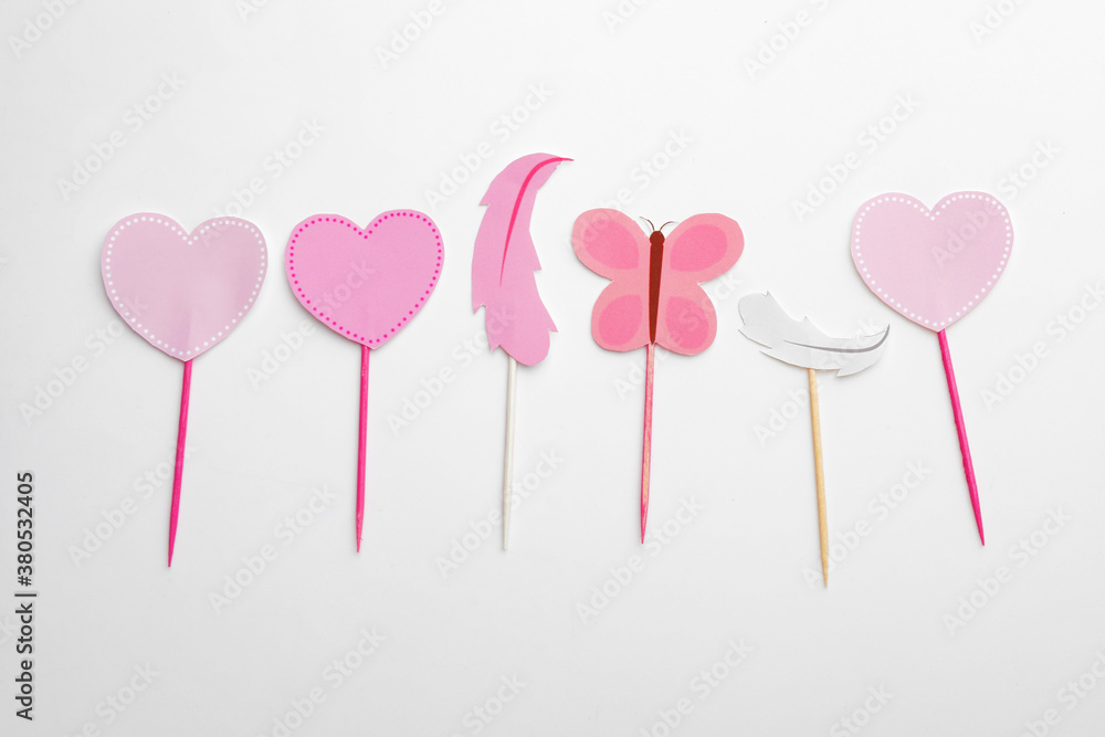 Stylish cupcake toppers on white background