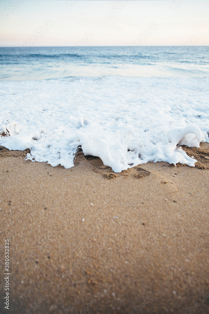 Waves crashing on sand during sunset Waves crashing on sand during sunset