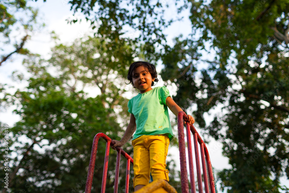 Little girl enjoying on the slide at a park Little girl enjoying on the slide at a park