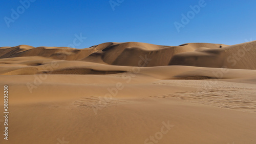 Beige colored sand dunes with blue sky near Swakopmund, Namib desert, Namibia, Africa.