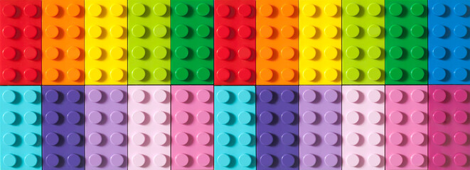 Many toy blocks in different colors making up one large square shape in top view. Toys and games. Leisure and recreation.