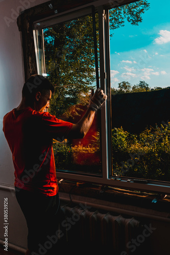 The worker inserts glass into the window frame, triple glazing of the plastic window, insulation and insulation. © Niko_Dali