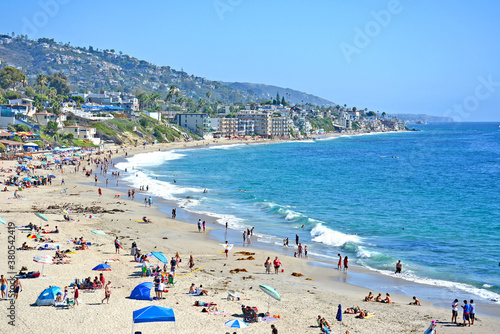 View of crowded Southern California beach and coastline in Laguna Beach, Orange County.