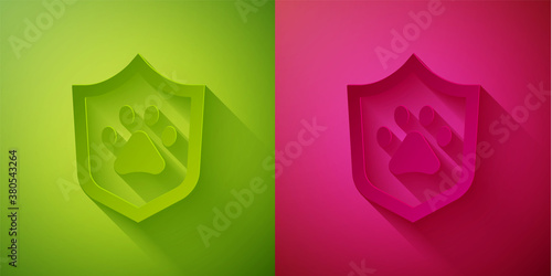 Paper cut Animal health insurance icon isolated on green and pink background. Pet protection concept. Dog or cat paw print. Paper art style. Vector.