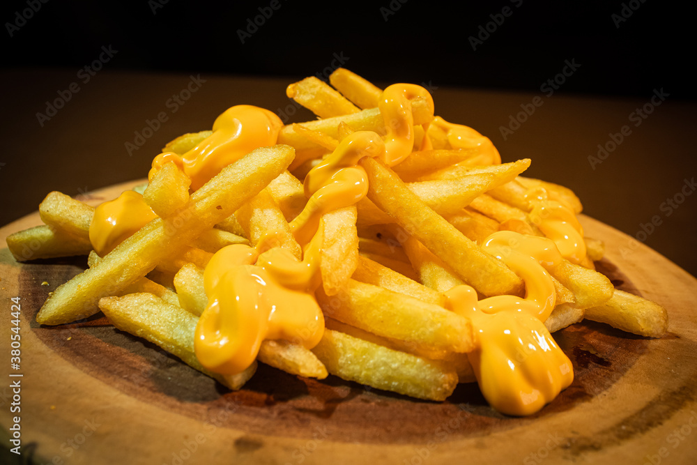 french fries with cheddar wooden background french fries with cheddar wooden background