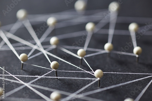 Close-up of white pins on black background creating a network