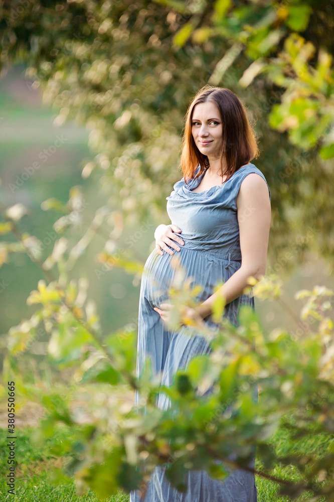 Beautiful pregnant woman outdoors, with pleasure expecting baby and having happy pregnancy time Beautiful pregnant woman outdoors, with pleasure expecting baby and having happy pregnancy time
