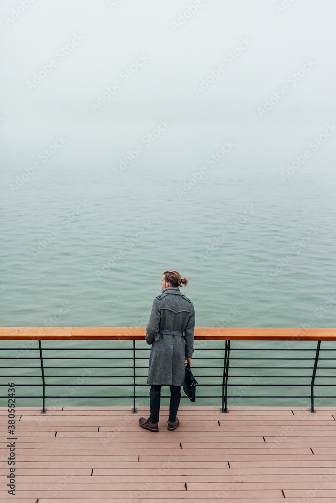 Young stylish businessman in the city by the river Young stylish businessman in the city by the river