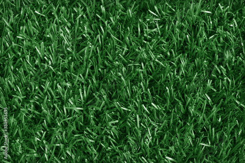Top view of artificial dark green grass texture background.