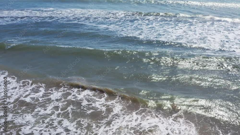 Sandy beach with ocean tidal waves crashing on a sandy beach splashing. Aerial drone video Sandy beach with ocean tidal waves crashing on a sandy beach splashing. Aerial drone video