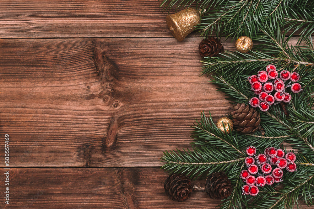 Christmas frame made of fir tree branches,cones,red viburnum berries on the dark wooden rustic background.Christmas background.Copy space for text, top view.