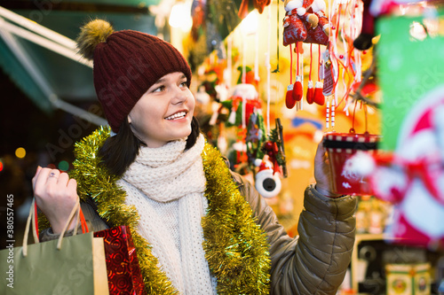 Smiling happy cheerful teenage girl shopping at festive fair before Xmas