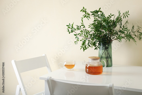 White kitchen table with tea and plant in bright room