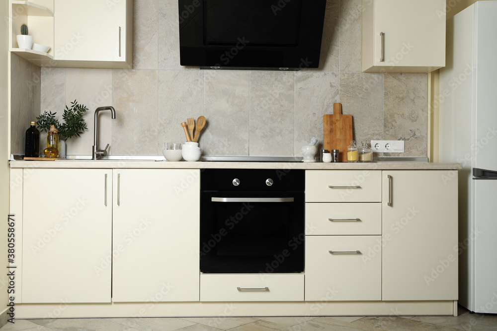 Modern kitchen interior with different supplies in light colors Modern kitchen interior with different supplies in light colors