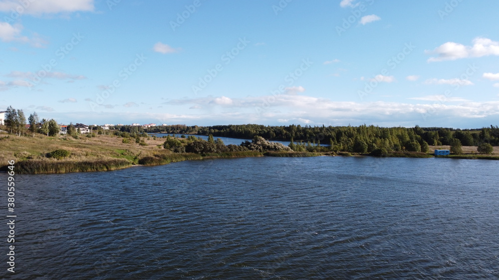 A view from a height of a beautiful calm shore of a forest lake