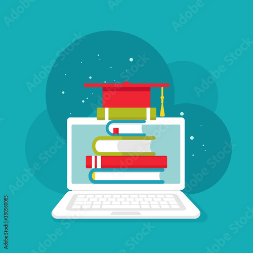 white laptop with stack of colorful books and graduation cap or mortar board.