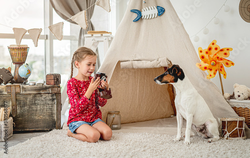 Little girl with camera next to dog photo