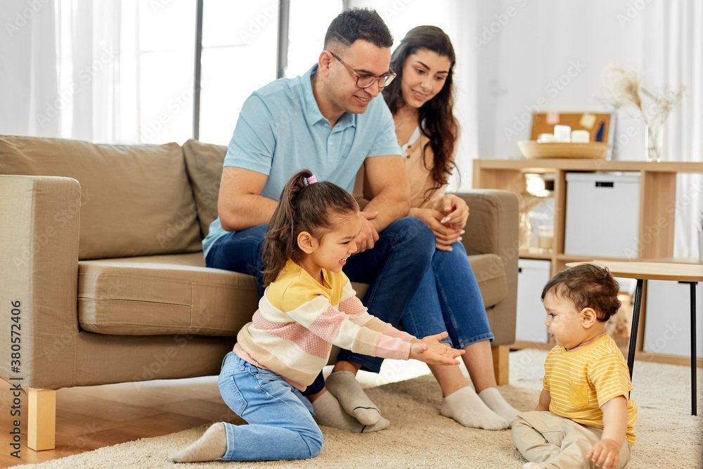 family and people concept - portrait of happy mother, father, little daughter and baby son sitting on sofa at home family and people concept - portrait of happy mother, father, little daughter and baby son sitting on sofa at home