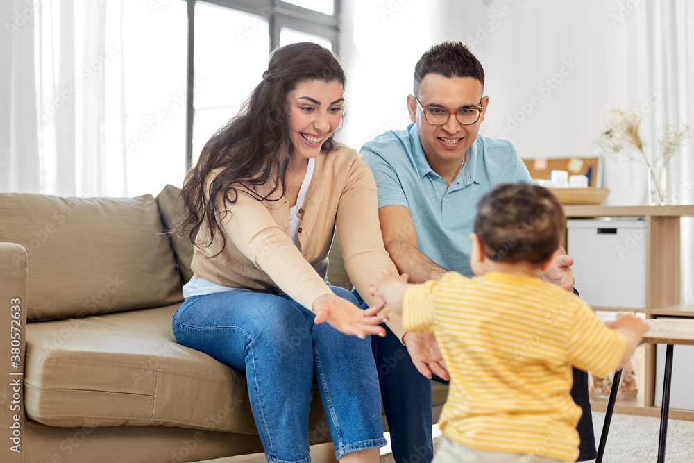 family and people concept - happy mother, father and baby son sitting on sofa at home family and people concept - happy mother, father and baby son sitting on sofa at home