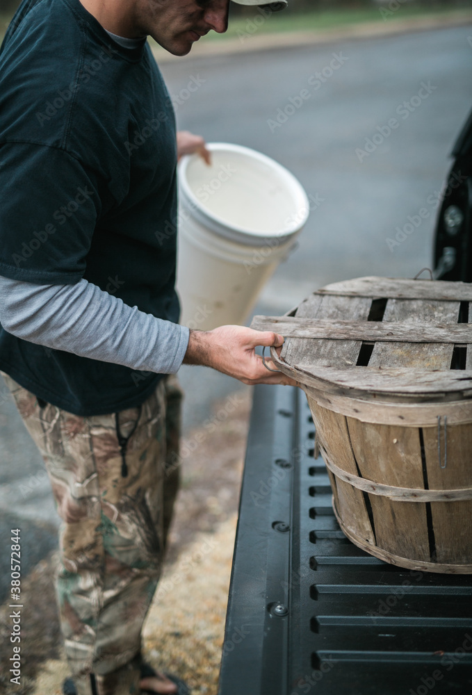 Man organizing storage baskets for fishing trip Man organizing storage baskets for fishing trip