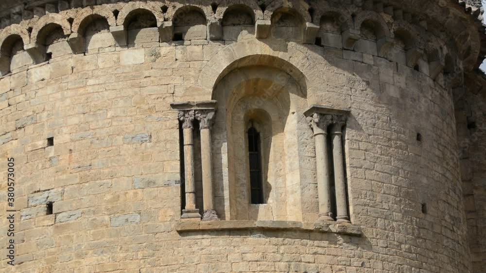 Still image of a window with columns on both sides and an upper arcade of the Romanesque church of San Cristóbal in the beautiful medieval town of Beget, Catalunya, Spain Still image of a window with columns on both sides and an upper arcade of the Romanesque church of San Cristóbal in the beautiful medieval town of Beget, Catalunya, Spain