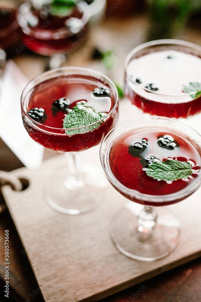 Blackberry gin cocktail with mint in crystal coupe glass Blackberry gin cocktail with mint in crystal coupe glass