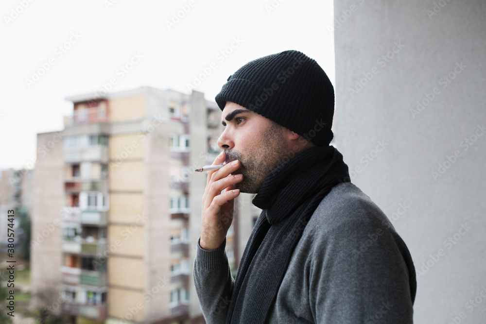 Portrait of a handsome man smoking on a terrace Portrait of a handsome man smoking on a terrace