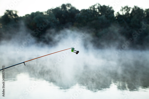 bell at the end of fishing rod.. morning evaporation of water over the river, fog over the water