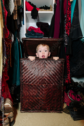 Child Hiding in Laundry Hamper photo