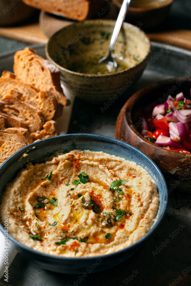 A bowl of hummus and bread and salad closeup. A bowl of hummus and bread and salad closeup.