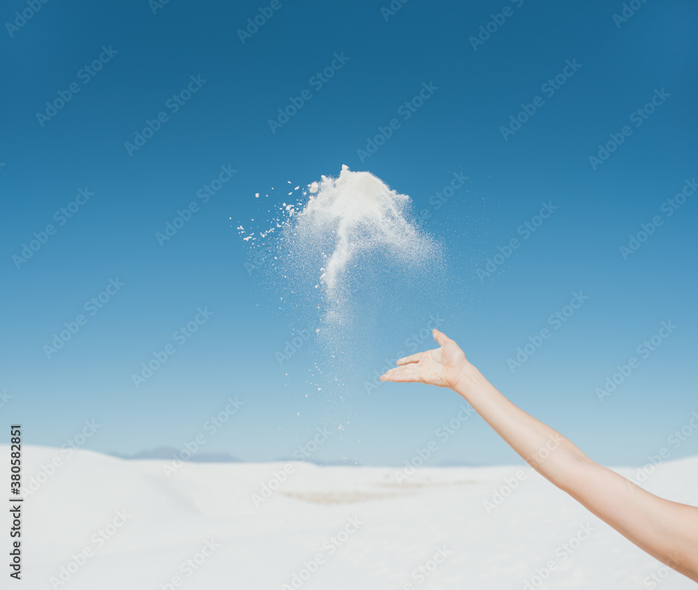 woman throws sand in air