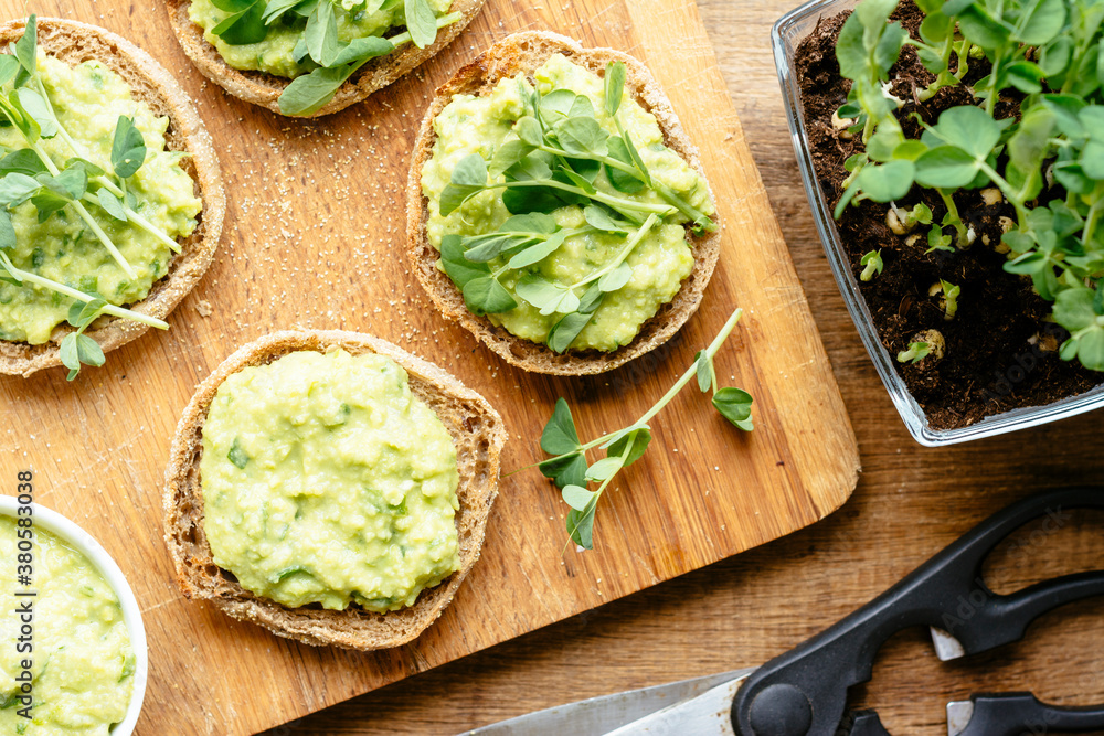 Muffins with an avocado/fava bean mash and pea sprouts Muffins with an avocado/fava bean mash and pea sprouts