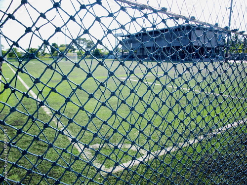 Futsal field net. On the background of futsal pitches with green artificial grass and outdoor office buildings on sunny days. Selective focus