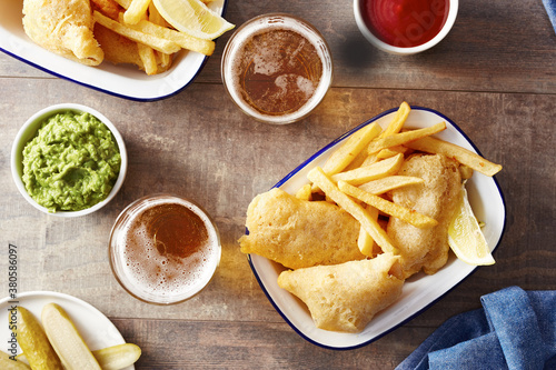 View on wooden table with beverages, snacks and sauces photo