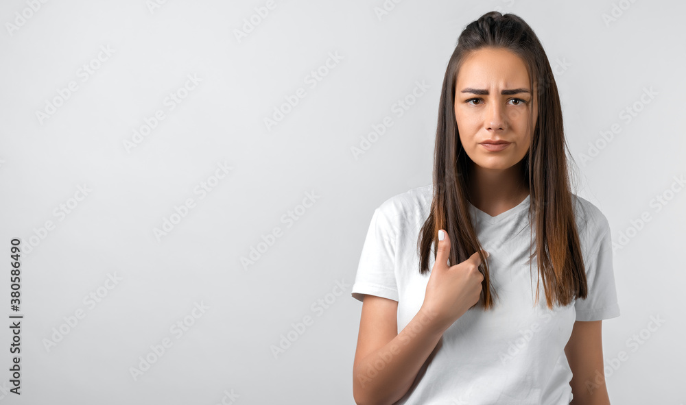 Portrait of beautiful brunette girl looking at camera suspiciously. Studio shot white background. Copy space Portrait of beautiful brunette girl looking at camera suspiciously. Studio shot white background. Copy space