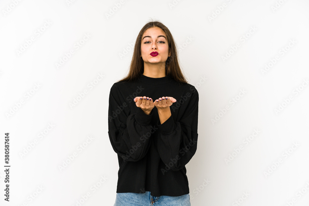Young caucasian woman isolated on white background folding lips and holding palms to send air kiss. Young caucasian woman isolated on white background folding lips and holding palms to send air kiss.