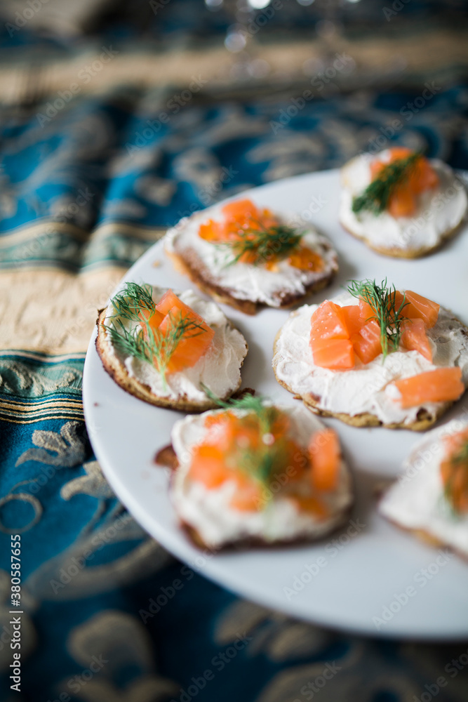 Dish of handmade blinies with smoked salmon and caviar on plate on furnished table. Dish of handmade blinies with smoked salmon and caviar on plate on furnished table.