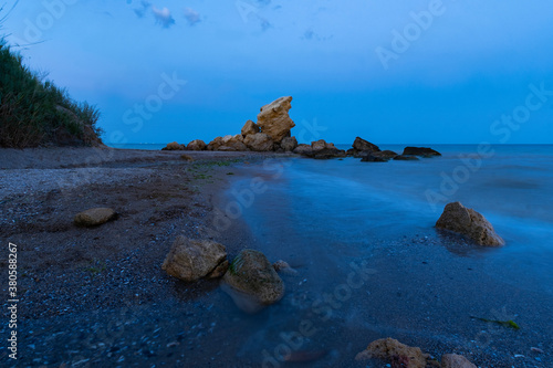 Landscape with sea, river and stones after sunset