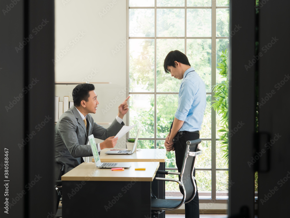 Disappointed Asian manager shouting at the employee for making big mistake inside the room in the office. Disappointed Asian manager shouting at the employee for making big mistake inside the room in the office.