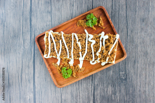 Top view Toast with shredded beef topped with mayonnaise. Served on wooden trays.
