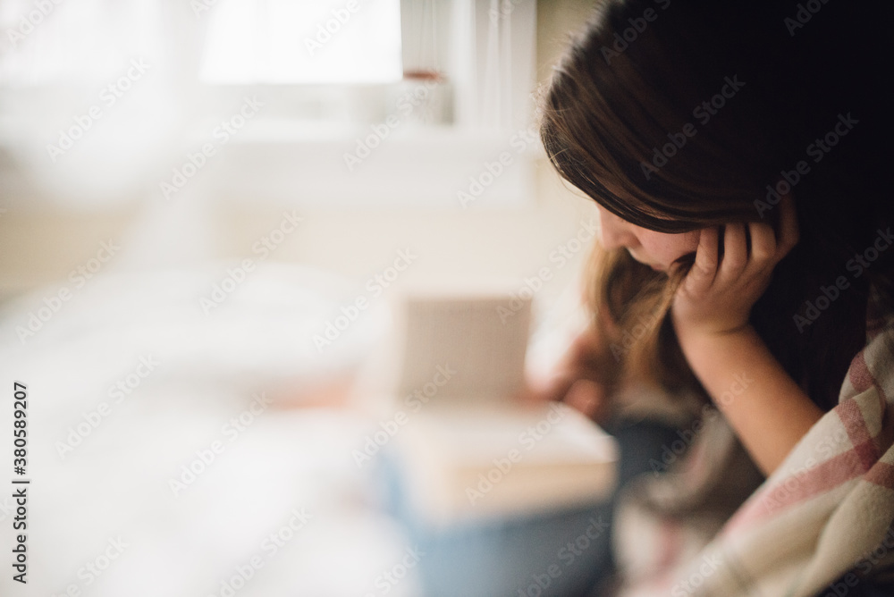 young woman reading on her bed