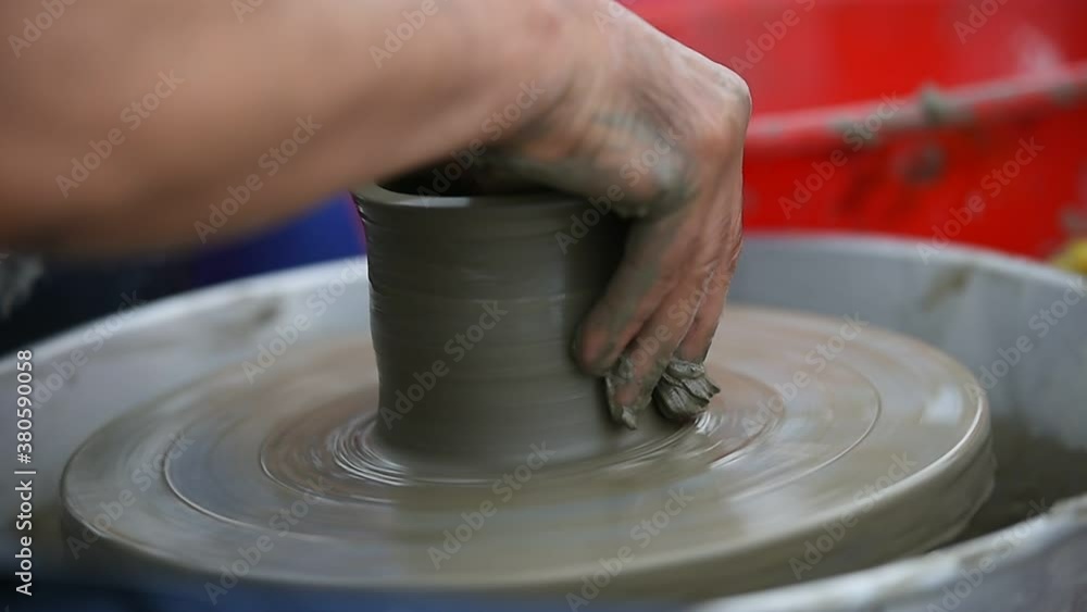 Detail with hands of an artist modeling a bowl on a pottery wheel Detail with hands of an artist modeling a bowl on a pottery wheel
