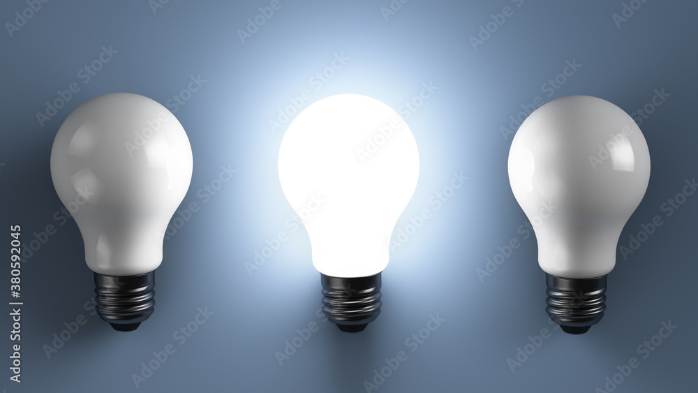 Three energy efficient lamps on the table. One of them shines. Three energy efficient lamps on the table. One of them shines.
