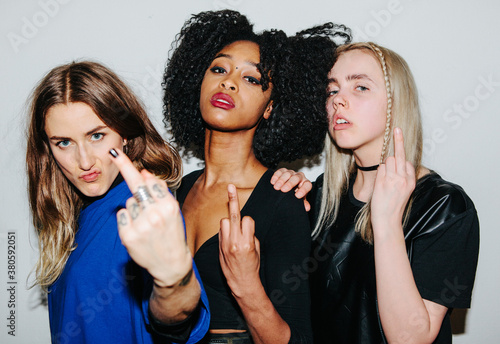 Three beautiful women flipping their middle fingers. photo