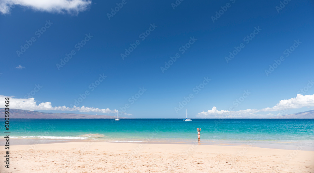 Young woman alone in paradise just coming out of the water after swimming