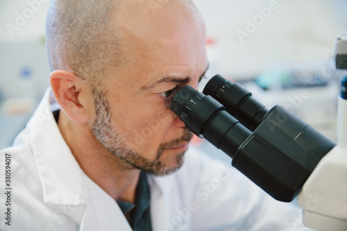 Científico mirando a través del microscopio