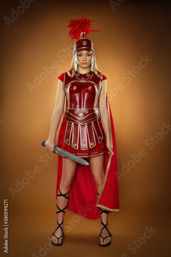 Fashion studio shot of beautiful woman in armour and helmet