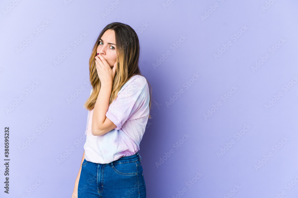 Young caucasian woman isolated on purple background covering mouth with hands looking worried. Young caucasian woman isolated on purple background covering mouth with hands looking worried.