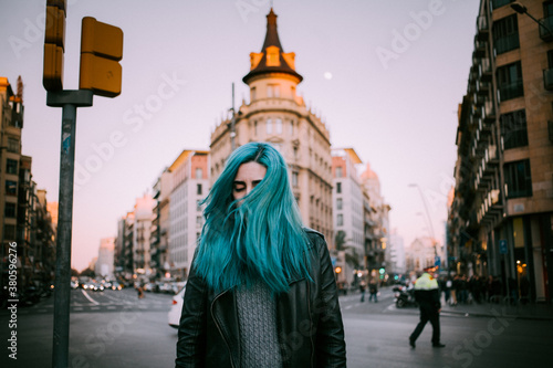 Blue haired woman at sunset in the city photo