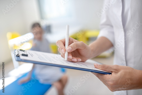 Doctor making notes after talking to a patient